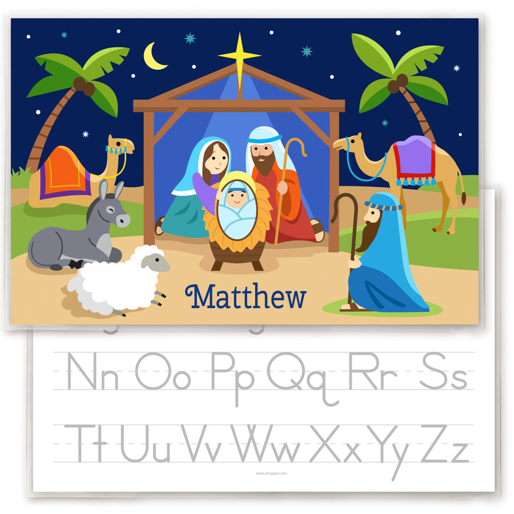 Kids personalized placemat with illustration of Nativity scene with manger, Mary Joseph and Baby Jesus, palm trees, shepherd, animals and the Christmas star.  Personalized with childs name at the bottom. Reverse side has alphabet letters for tracing.