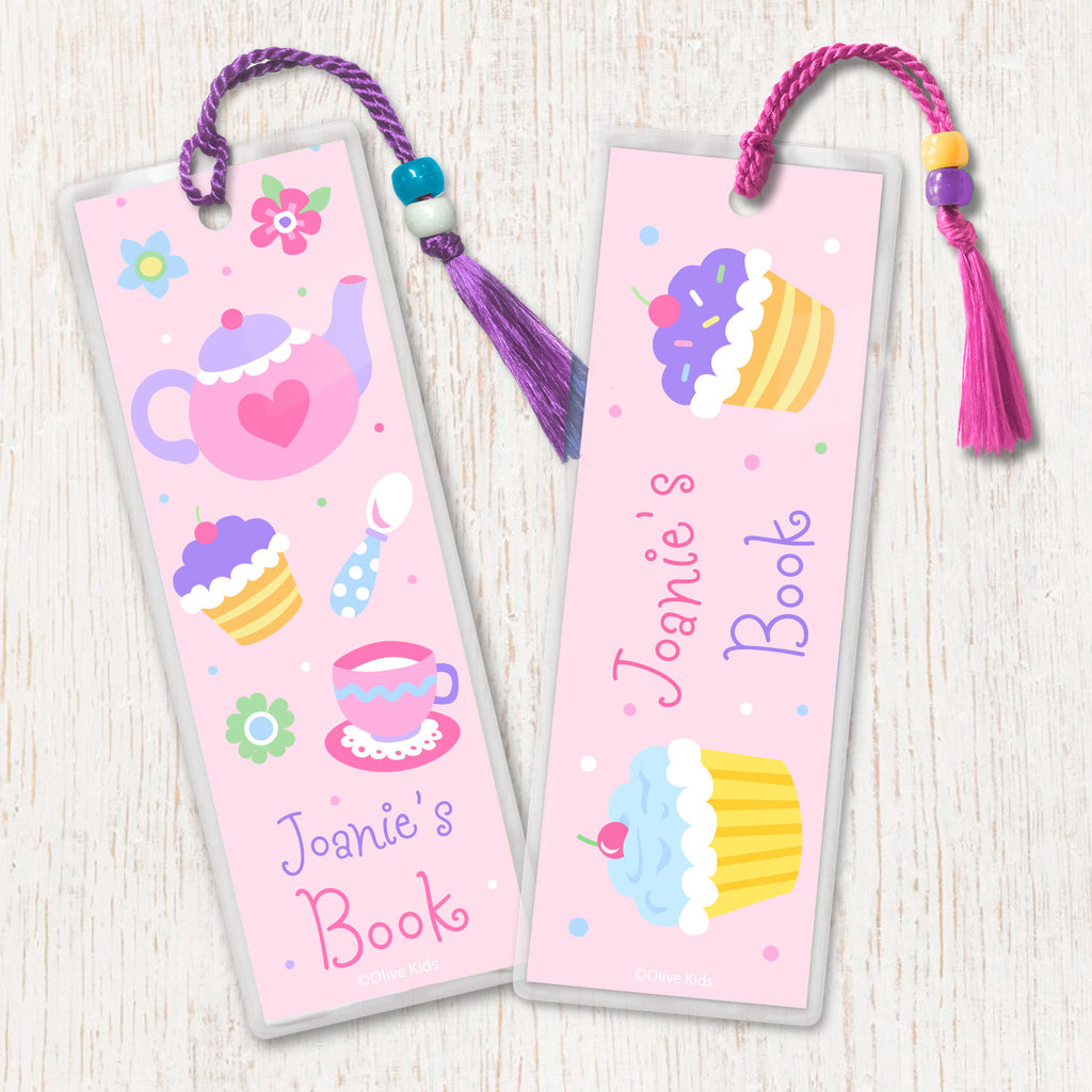 Kids personalized bookmarks with Tea Party theme. Teapot, teacups and cupcakes on a light pink background, decorated with tassel and beads.