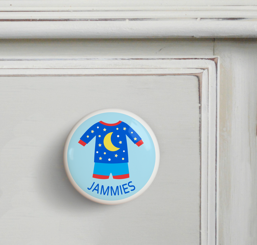 Ceramic drawer knob on a dresser, blue pajamas with yellow moon and stars on a light blue ground with the word jammies written below