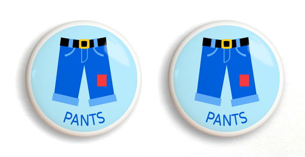 2 ceramic drawer knobs with boy's blue pants on a light blue ground with the word pants written below