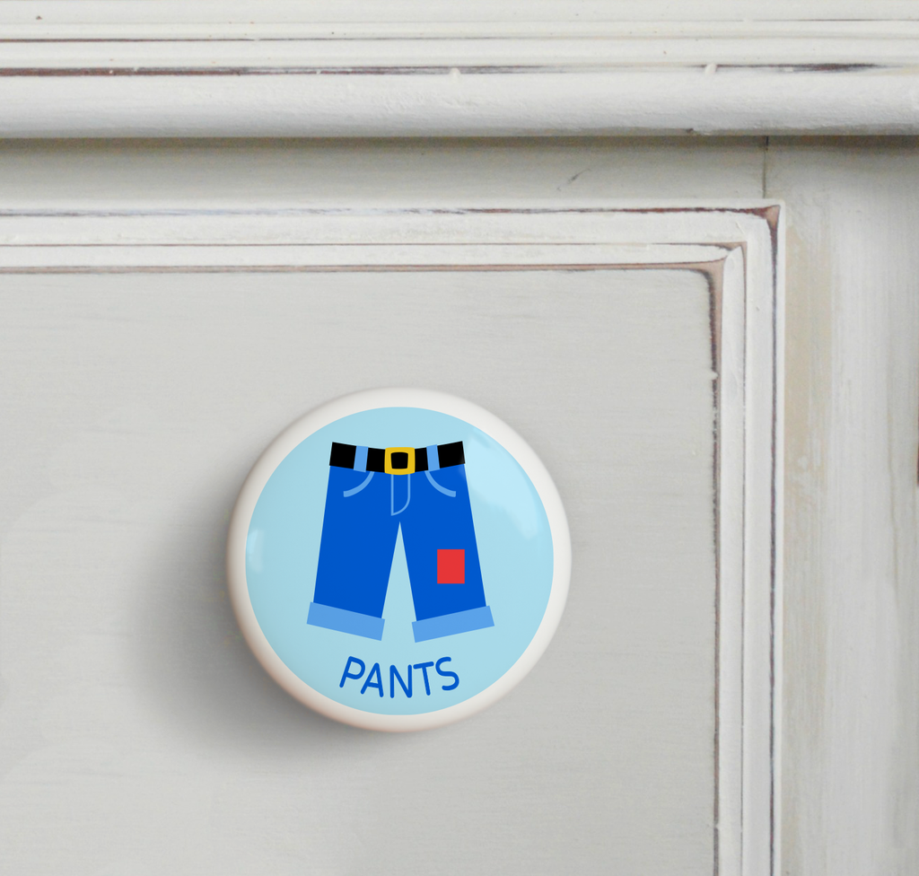 Ceramic drawer knob on a dresser, blue pants on a light blue ground with the word socks written below