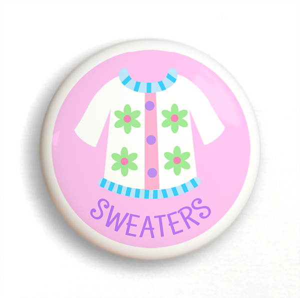 Ceramic drawer knob with a Girl's white sweater on a pink background with the word Sweaters written below