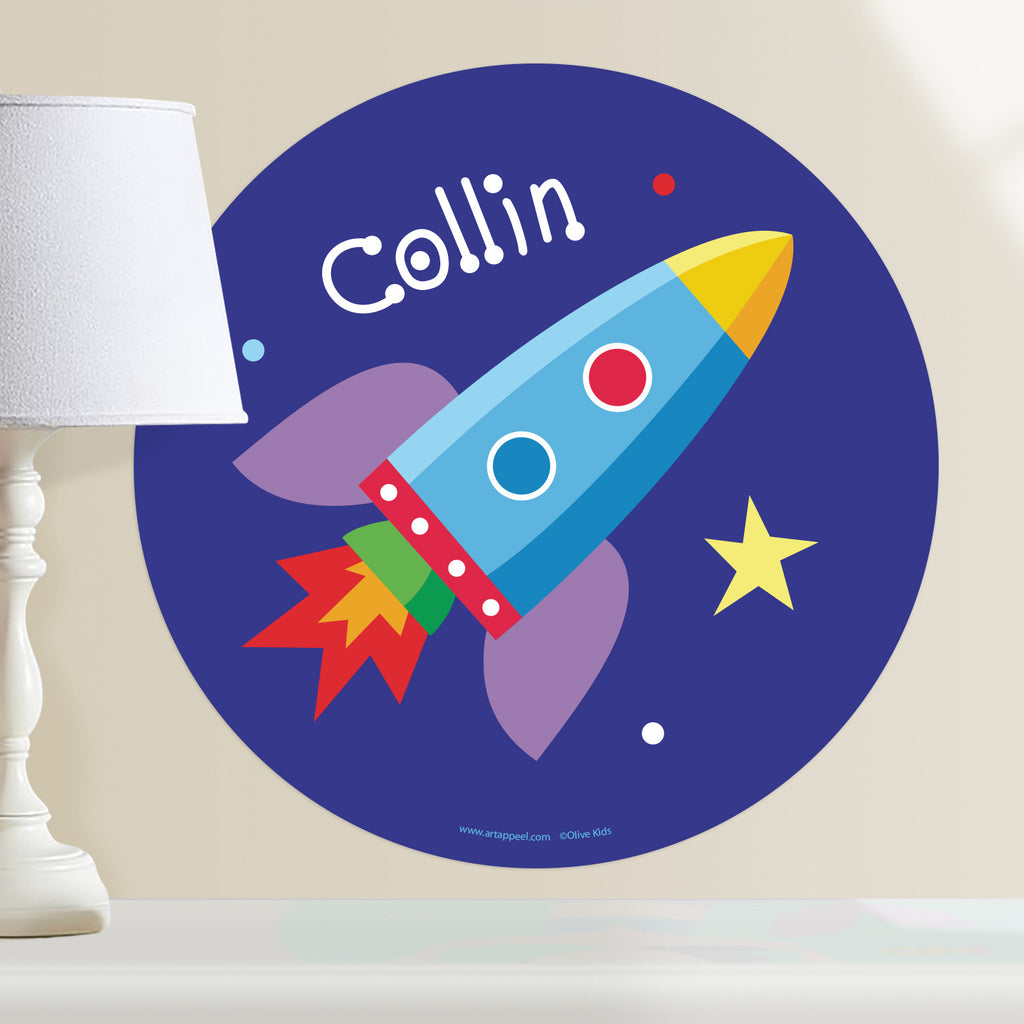 Rocket ship personalized kids wall decal.  Space theme features colorful rocketship on dark blue background with stars. Circle shape.