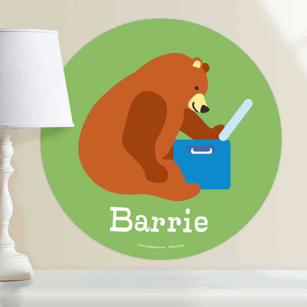 Personalized circular wall decal with a kid's name and a green background featuring a brown bear eating out of a cooler on a camping trip