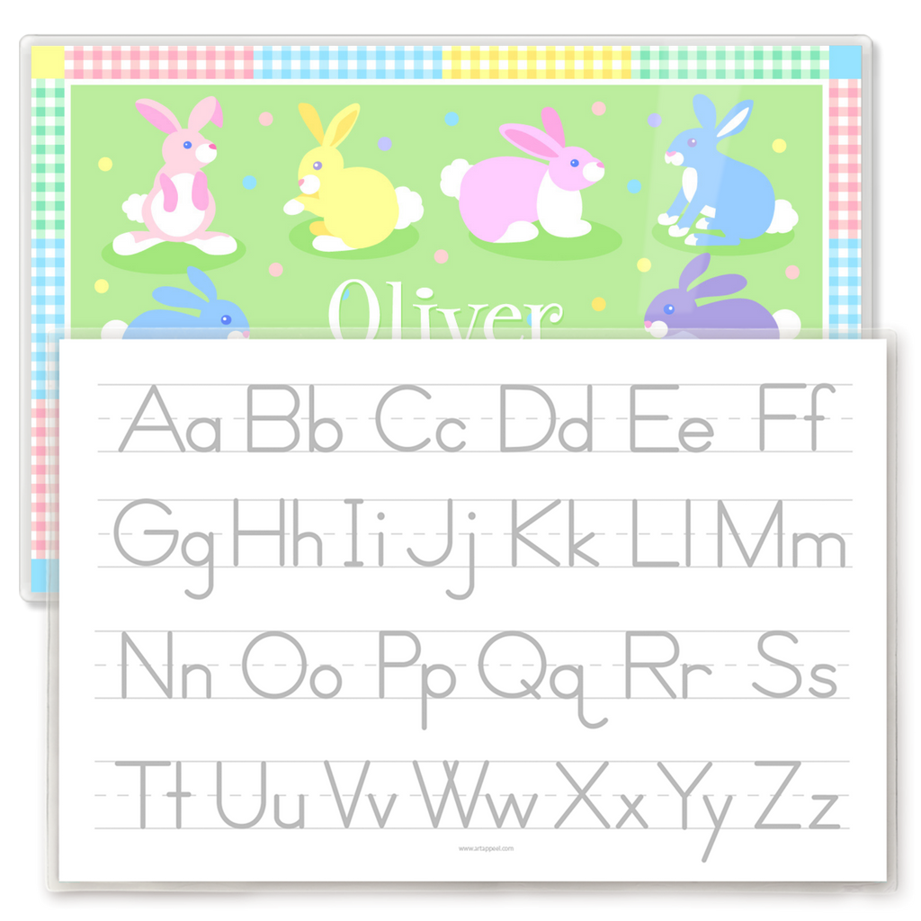 Kids placemat reverse side featuring a gray alphabet writing guide with uppercase and lowercase letters on lined handwriting practice rows, with pastel Easter bunny placemat design visible behind.