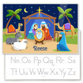 Kids personalized placemat with illustration of Nativity scene with manger, Mary Joseph and Baby Jesus, palm trees, shepherd, animals and the Christmas star.  Personalized with childs name at the bottom. Reverse side has alphabet letters for tracing.