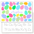 Personalized Easter placemat featuring colorful patterned eggs in pastel shades of pink, blue, green, yellow, and purple surrounding the name Angelina in a playful script font. The festive Easter egg designs include stripes, polka dots, zigzags, waves, and geometric patterns on a light gray background. Laminated kids placemat shown over an alphabet handwriting practice sheet.