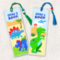 Kids personalized name bookmarks with dinosaurs in a prehistoric landscape, decorated with tassell and beads.