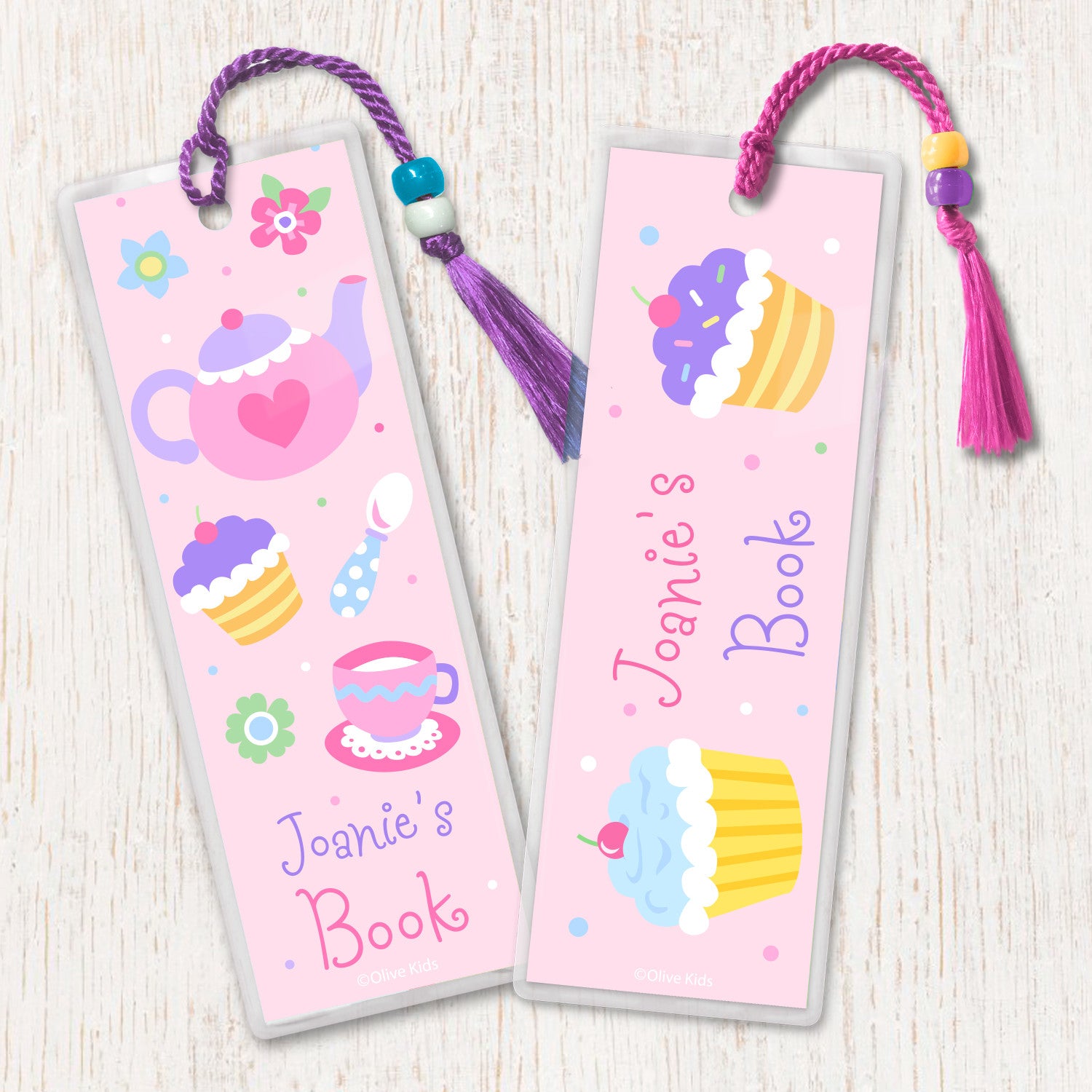 Kids personalized bookmarks with Tea Party theme. Teapot, teacups and cupcakes on a light pink background, decorated with tassel and beads.