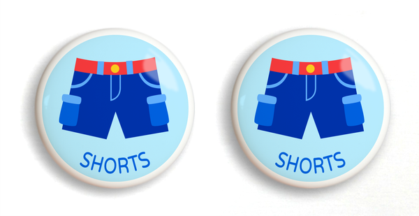 2 Ceramic drawer knobs with boys shorts on a light blue ground with the word Shorts written below