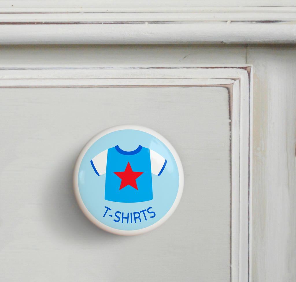 Ceramic drawer knob on a dresser, with boy's t-shirt  on a light blue ground with the word T-Shirts written below