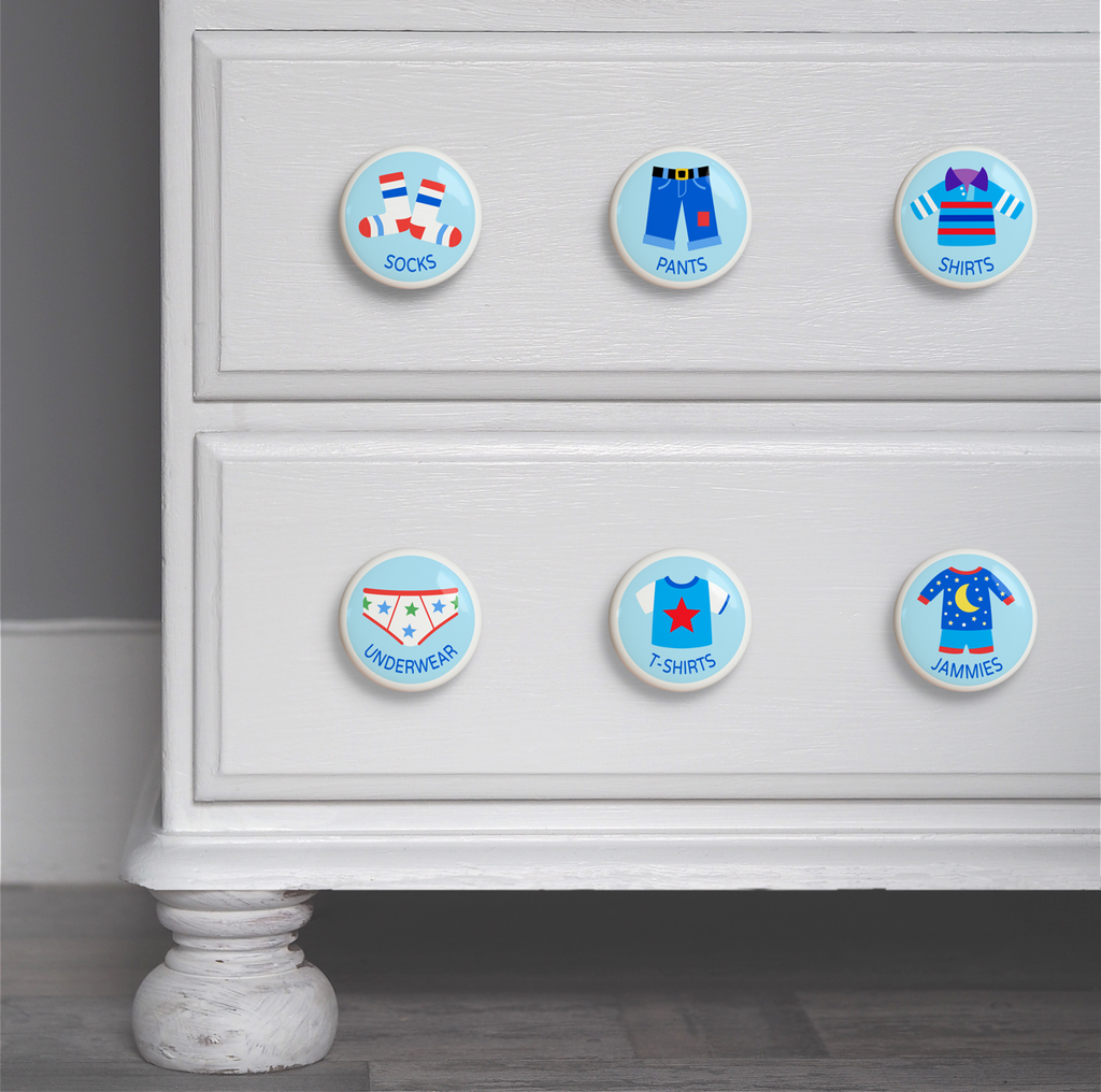 Boys ceramic drawer knob on a dresser set of 6, one each of socks, underwear, pajamas, shirts, t-shirts, and pants