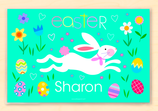 Personalized Easter Bunny Placemat for kids with white bunny running across blue green ground, with pastel color easter eggs and flowers