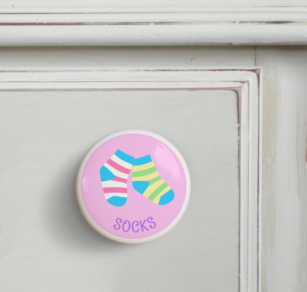 Ceramic drawer knob on a dresser, striped girls socks on a pink background with the word Socks written below