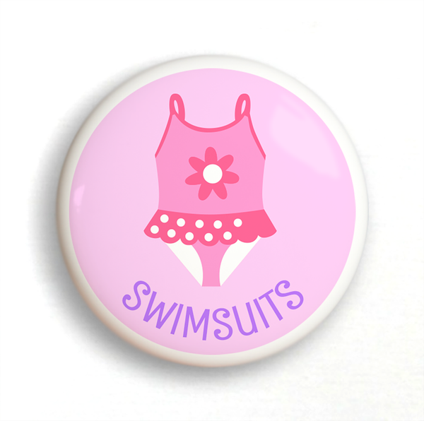 Ceramic drawer knob, girl's bathing suit on a pink background with the word Swimsuits written below