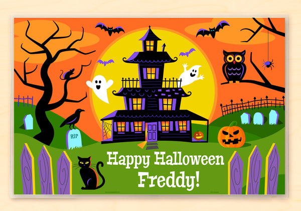 Kid Halloween place mat with a spooky house, ghosts, bats and other Halloween icons on an orange background with a large yellow full moon. Child name is in on the bottom with Happy Halloween.