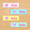 Butterfly garden kids spring personalized name waterproof labels with butterfly, flower, and ladybug in pastel colors on pink, blue and yellow backgrounds