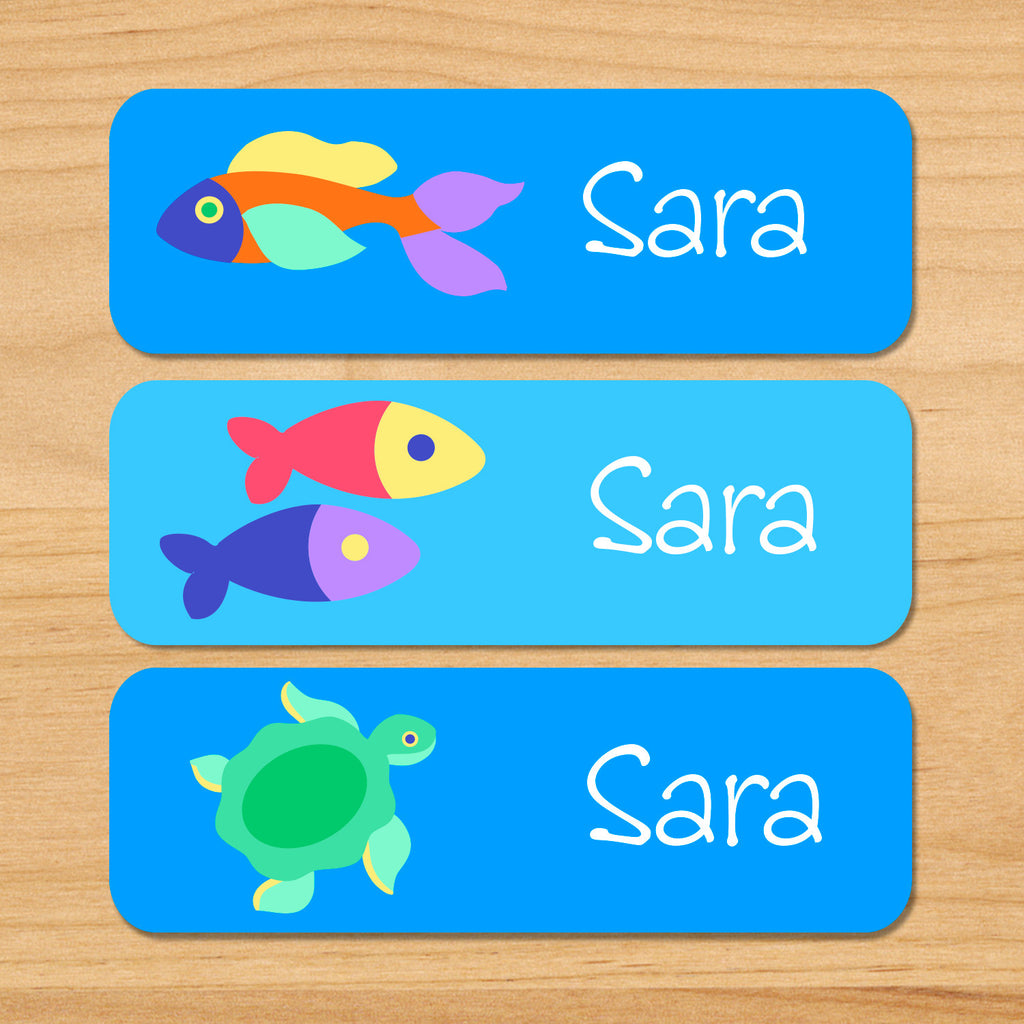 Somethin' fishy personalized ocean kids waterproof labels with name, colorful fish, and sea turtle on blue ocean water background