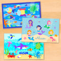 Girls personalized ocean themed placemats with colorful mermaids, playful dolphins, and tropical fish under the sea