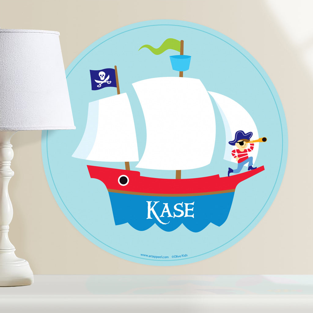Pirate ship personalized kids wall decal. Circular shape with pirate ship and kid pirate sailing the ocean.  Light blue background.